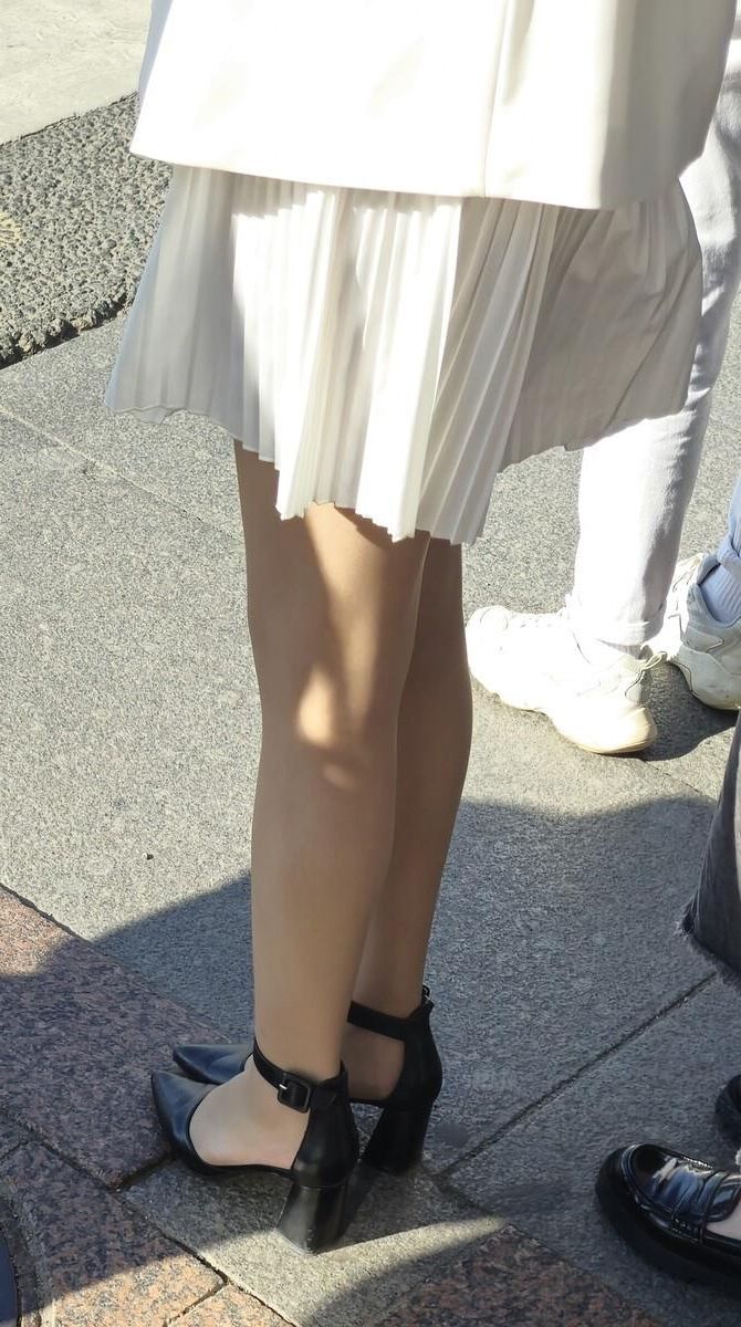 Menina de vestido branco, meias brilhantes e saltos de couro