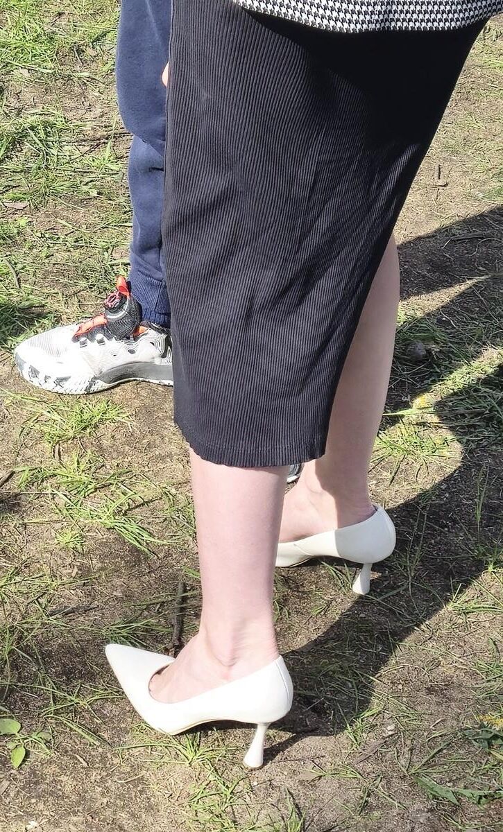 Garota de salto branco, vestido longo e jaqueta
