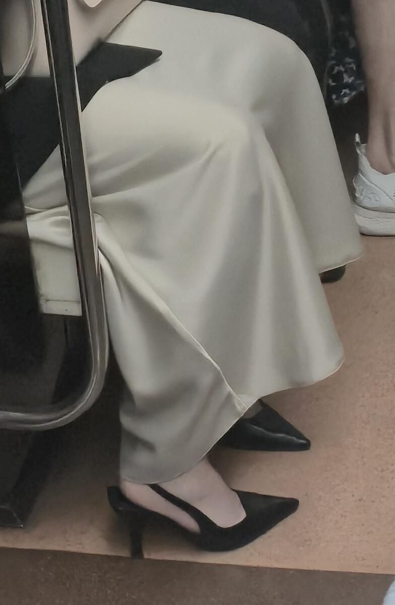 長いサテンのドレス、かかと、ジャケットを着た女の子