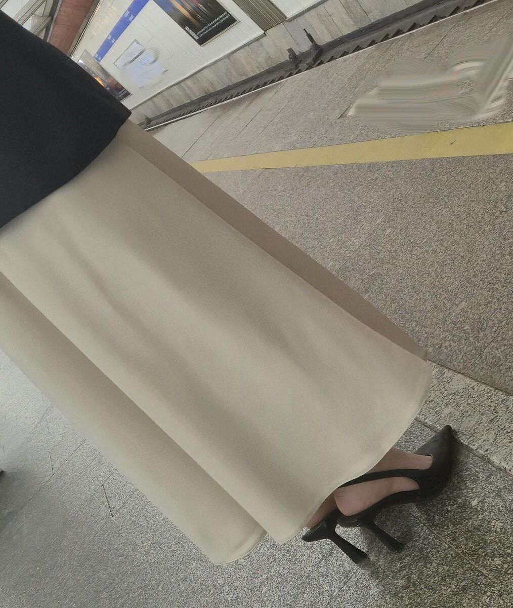 長いサテンのドレス、かかと、ジャケットを着た女の子