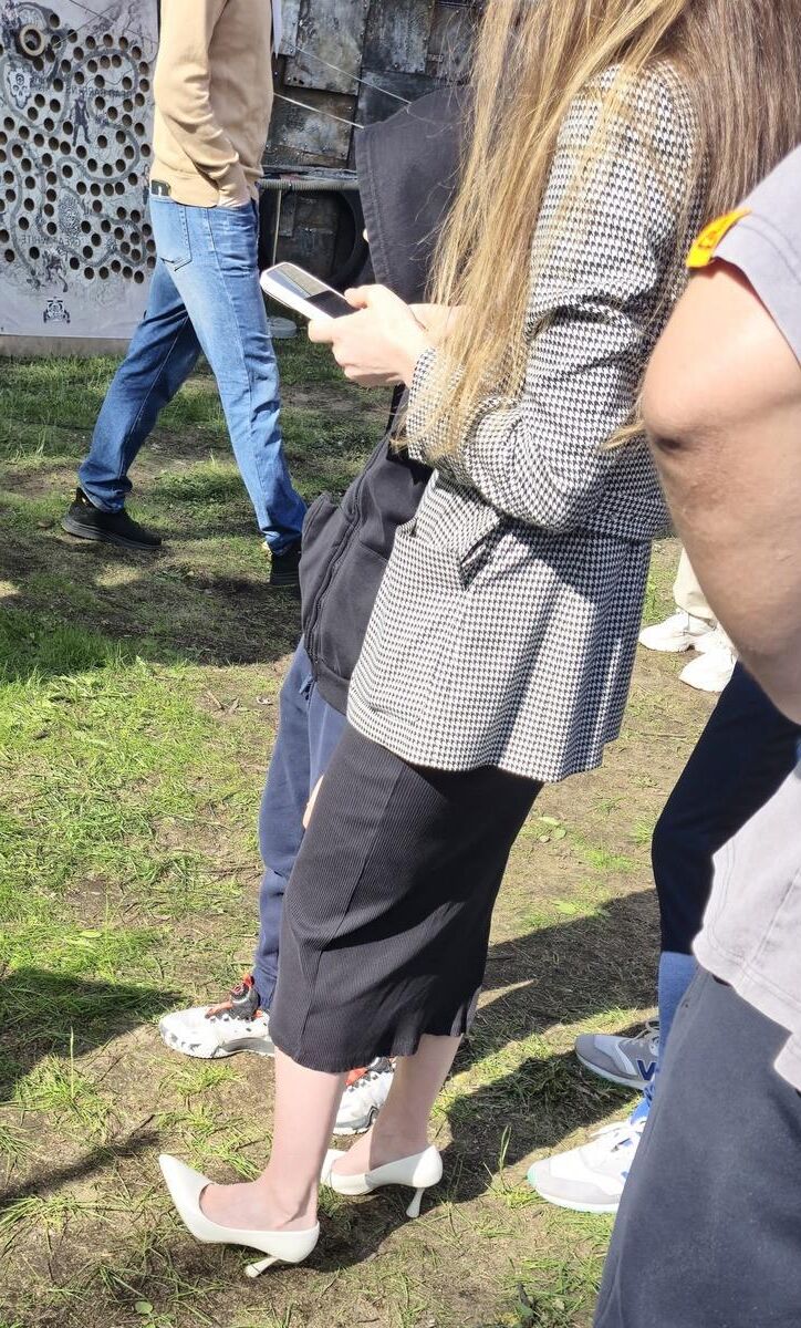 Garota de salto branco, vestido longo e jaqueta