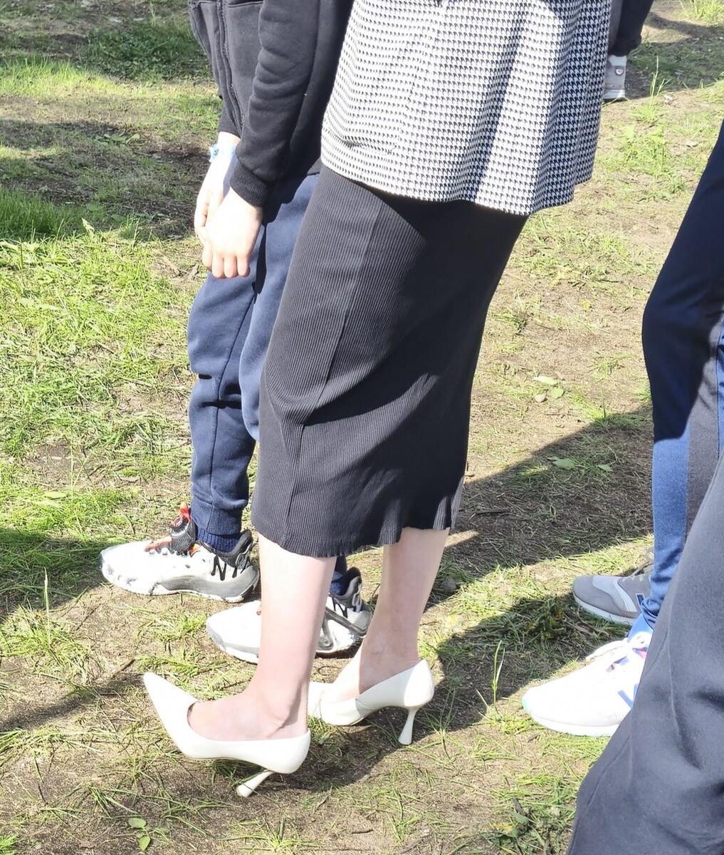 Garota de salto branco, vestido longo e jaqueta