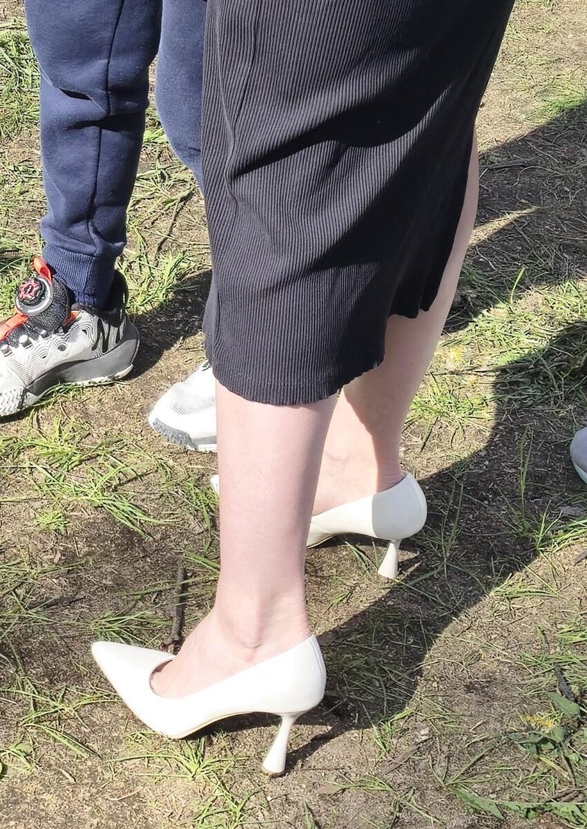 Garota de salto branco, vestido longo e jaqueta