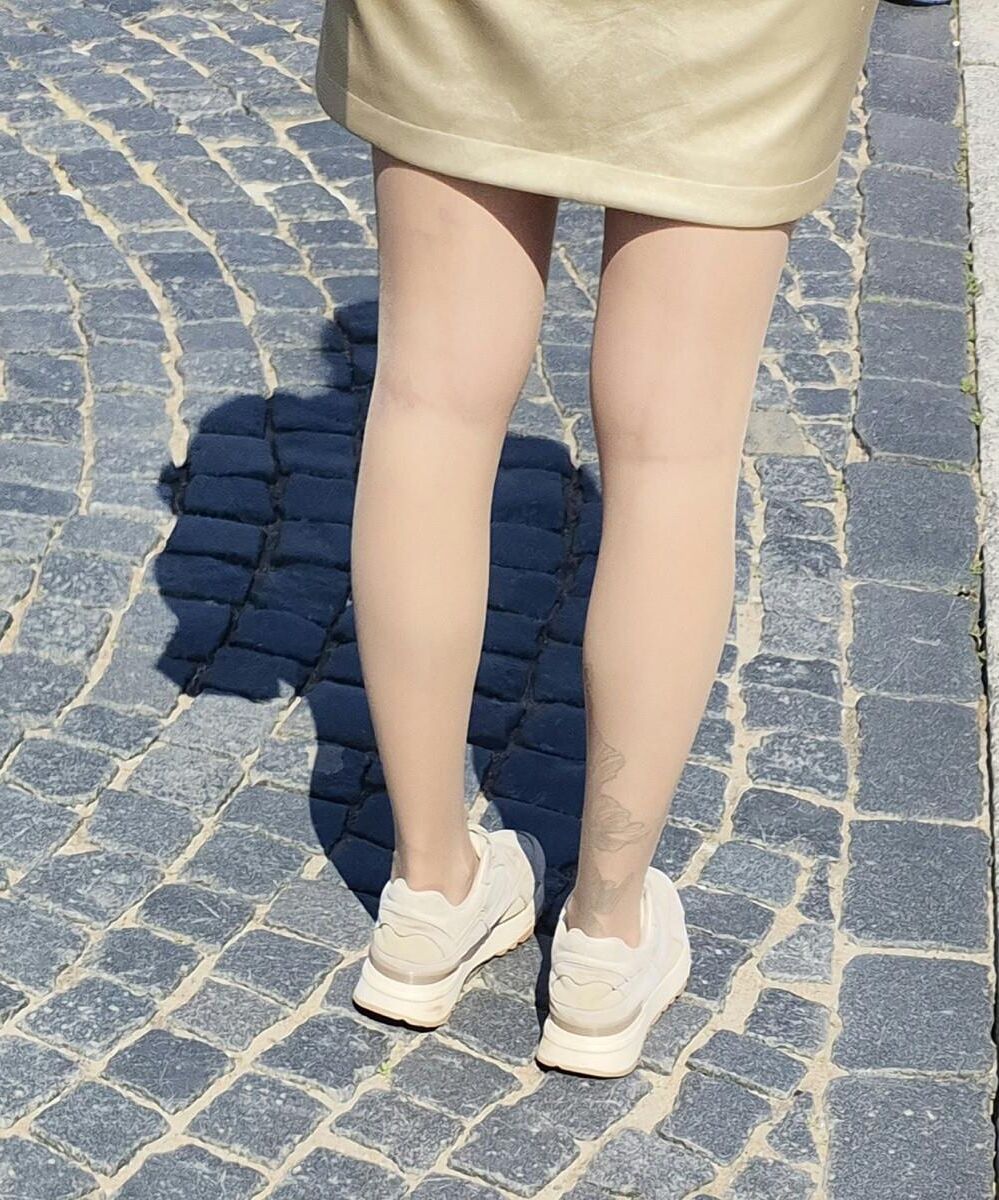 光沢のあるパンストとサテンのスカートの女の子