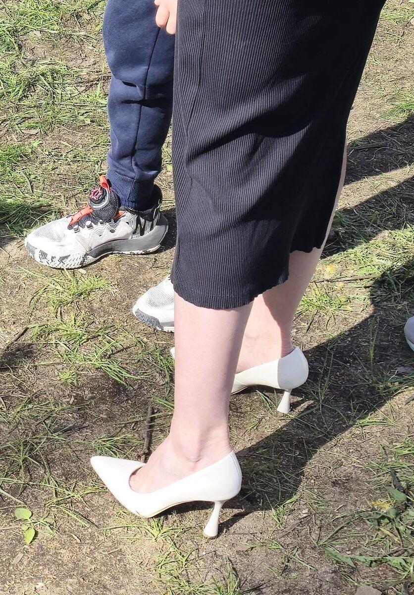 Garota de salto branco, vestido longo e jaqueta