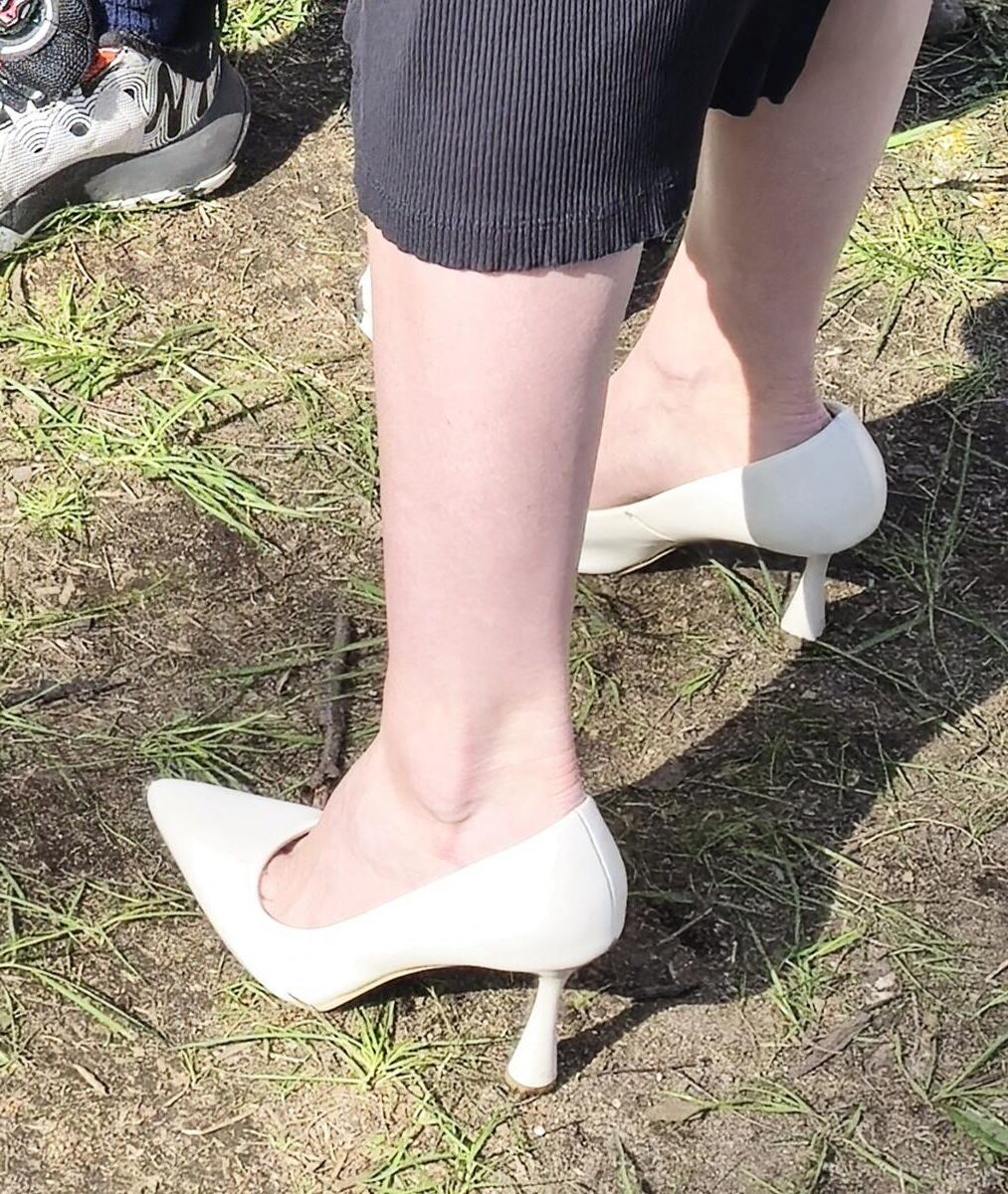 Garota de salto branco, vestido longo e jaqueta