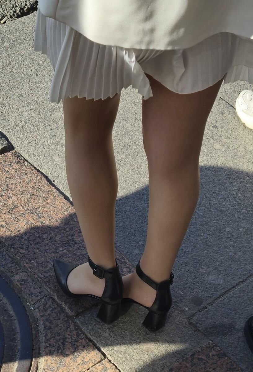 Menina de vestido branco, meias brilhantes e saltos de couro