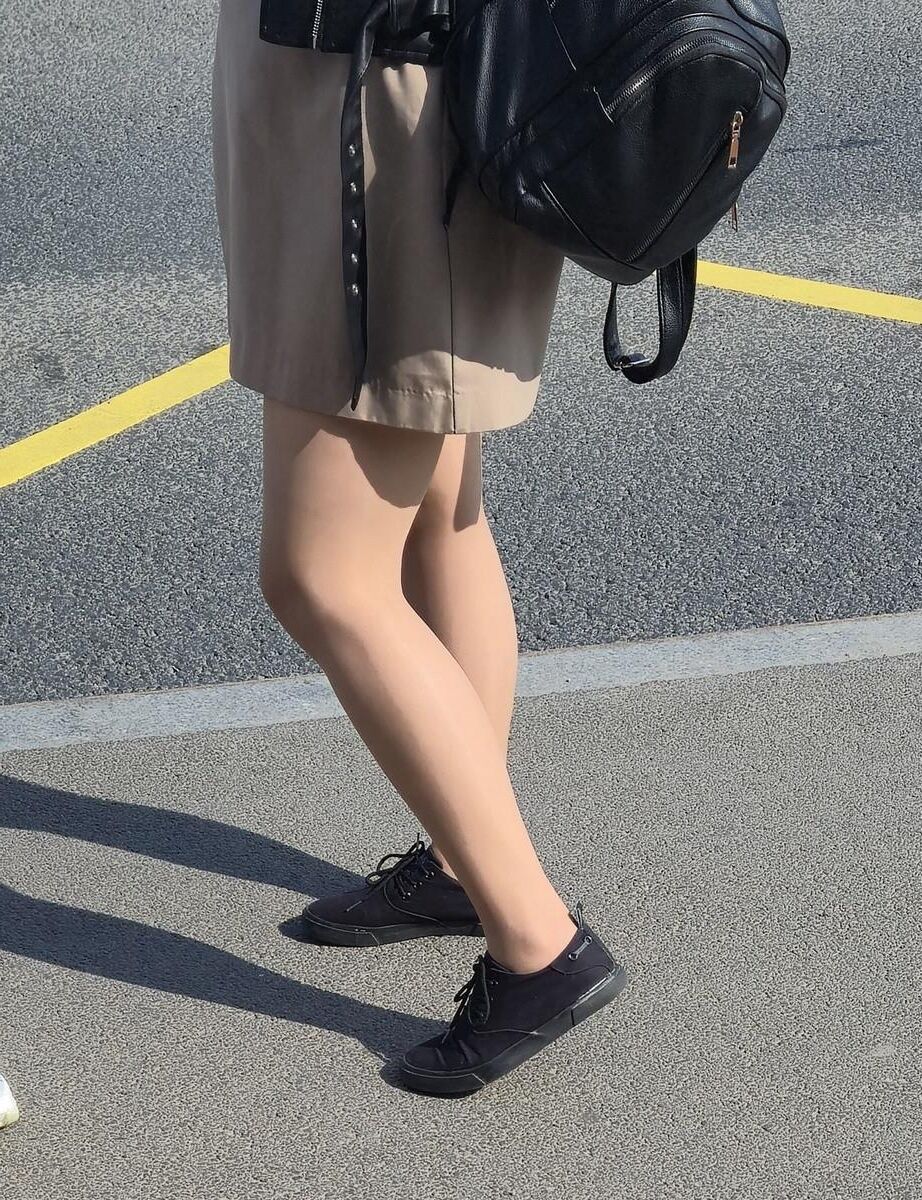 日焼けした光沢のあるパンストとミニスカートの女の子