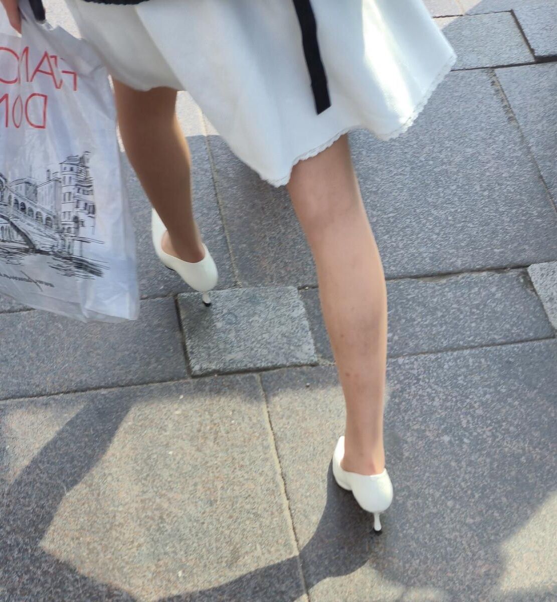 Menina de calças calças nus, saltos brancos e vestido branco