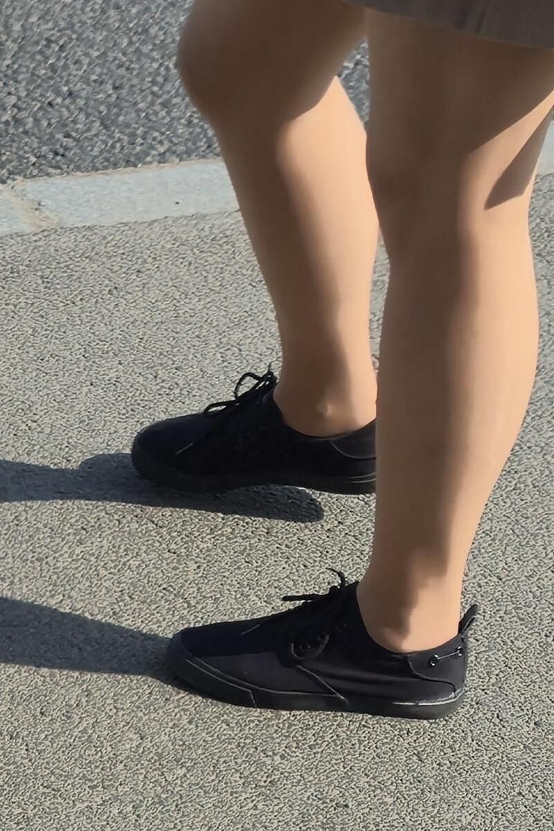 日焼けした光沢のあるパンストとミニスカートの女の子