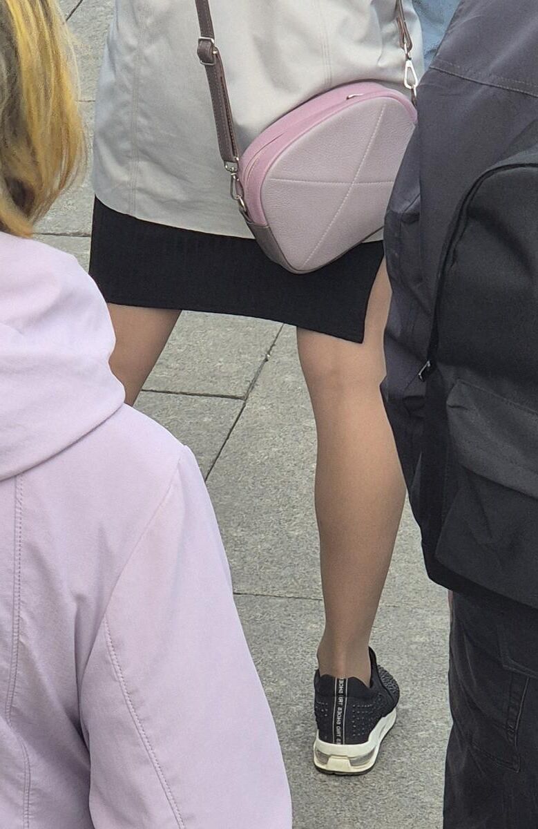 Garota em meia -calça bronzeada e mini -saia