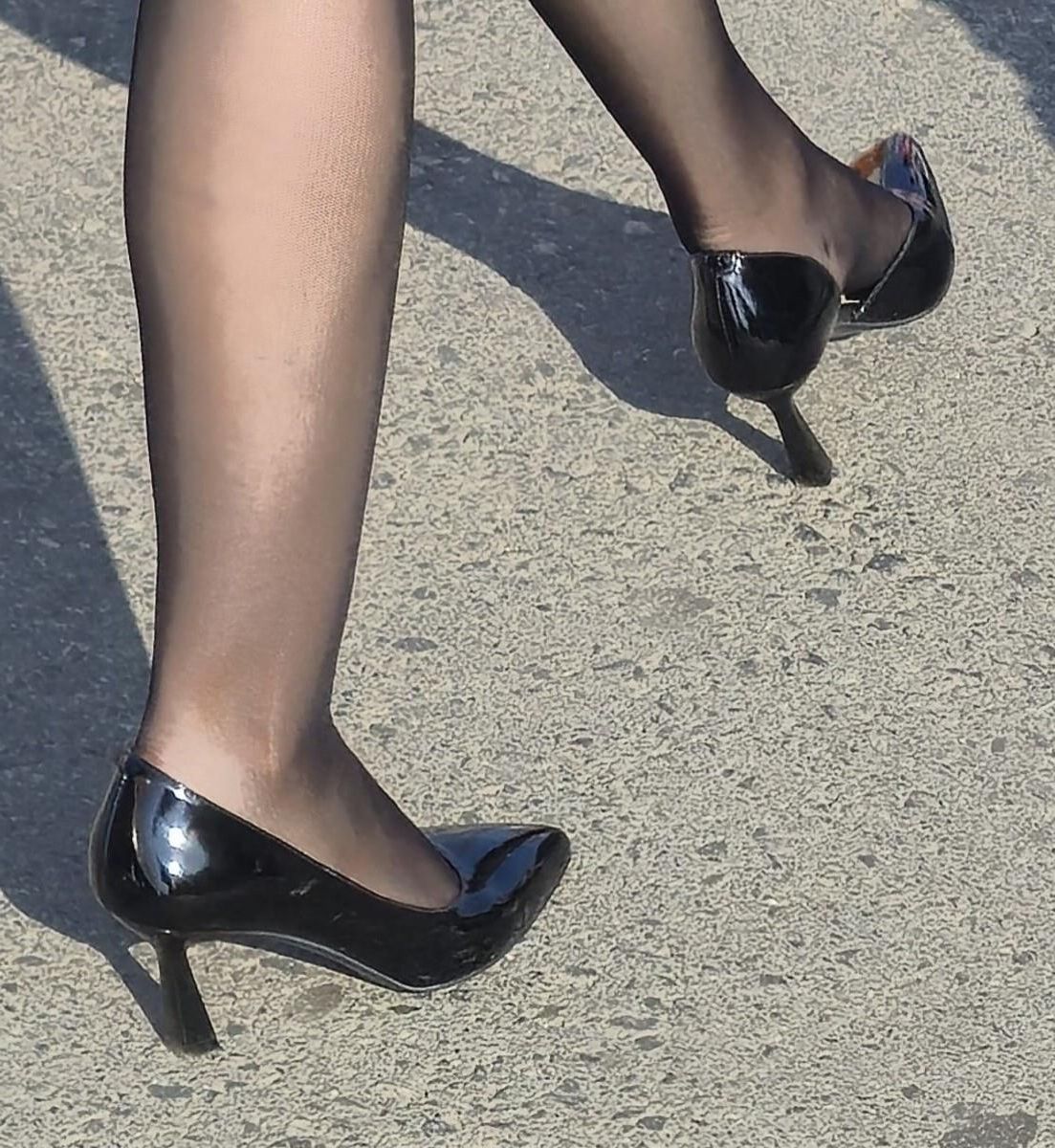 黒いタイツの女性、特許革のかかと、ミディスカート