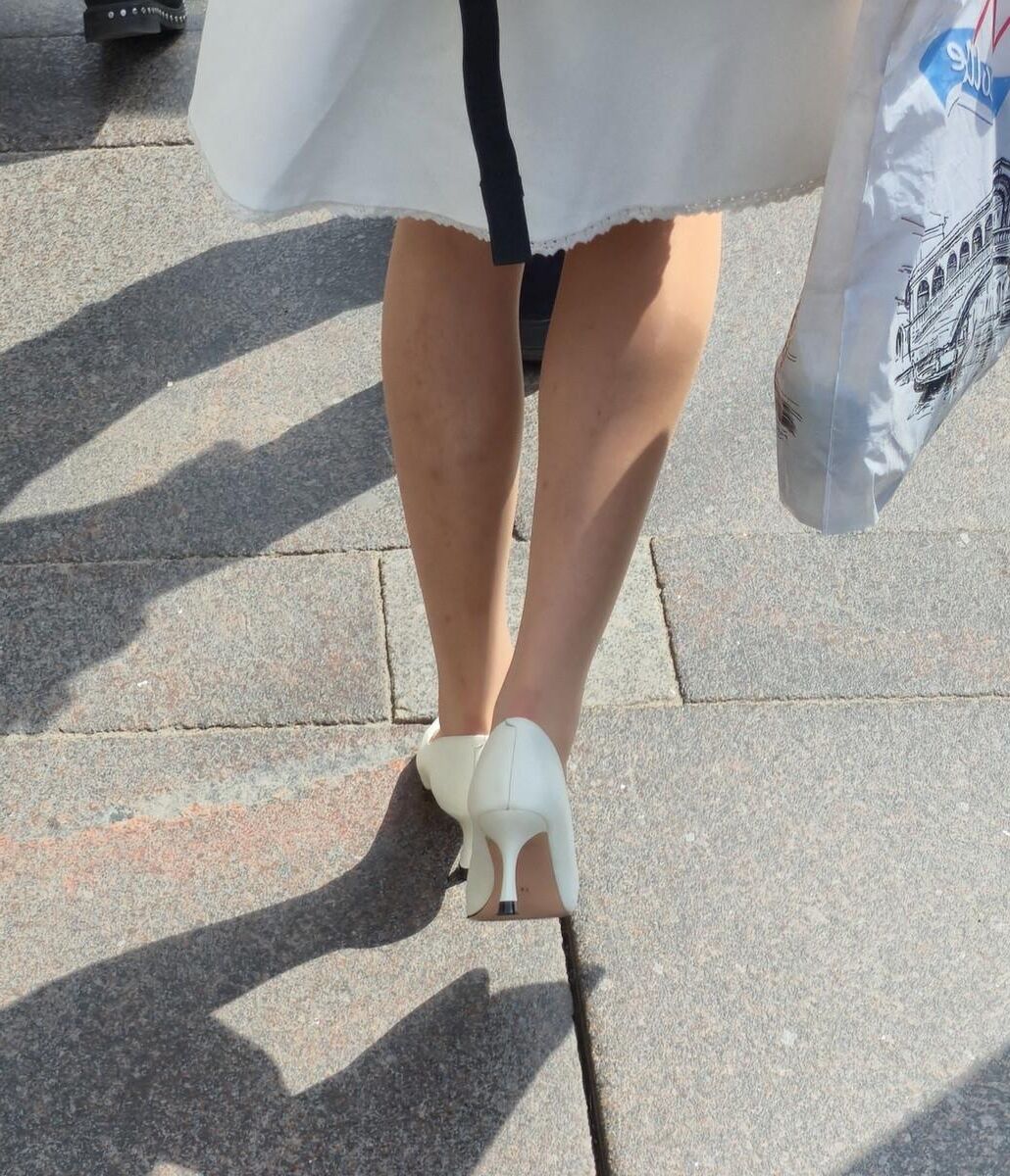 Menina de calças calças nus, saltos brancos e vestido branco