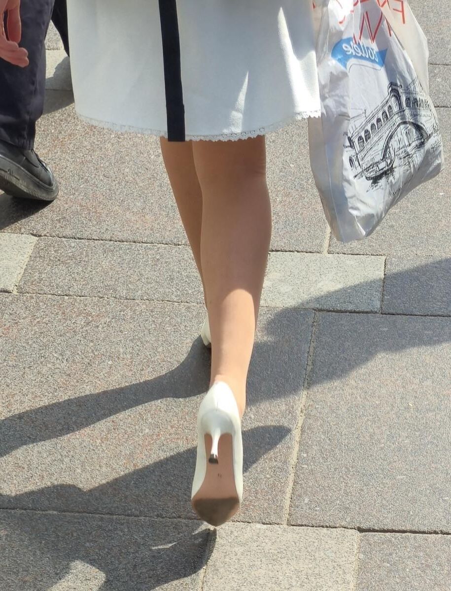 Menina de calças calças nus, saltos brancos e vestido branco
