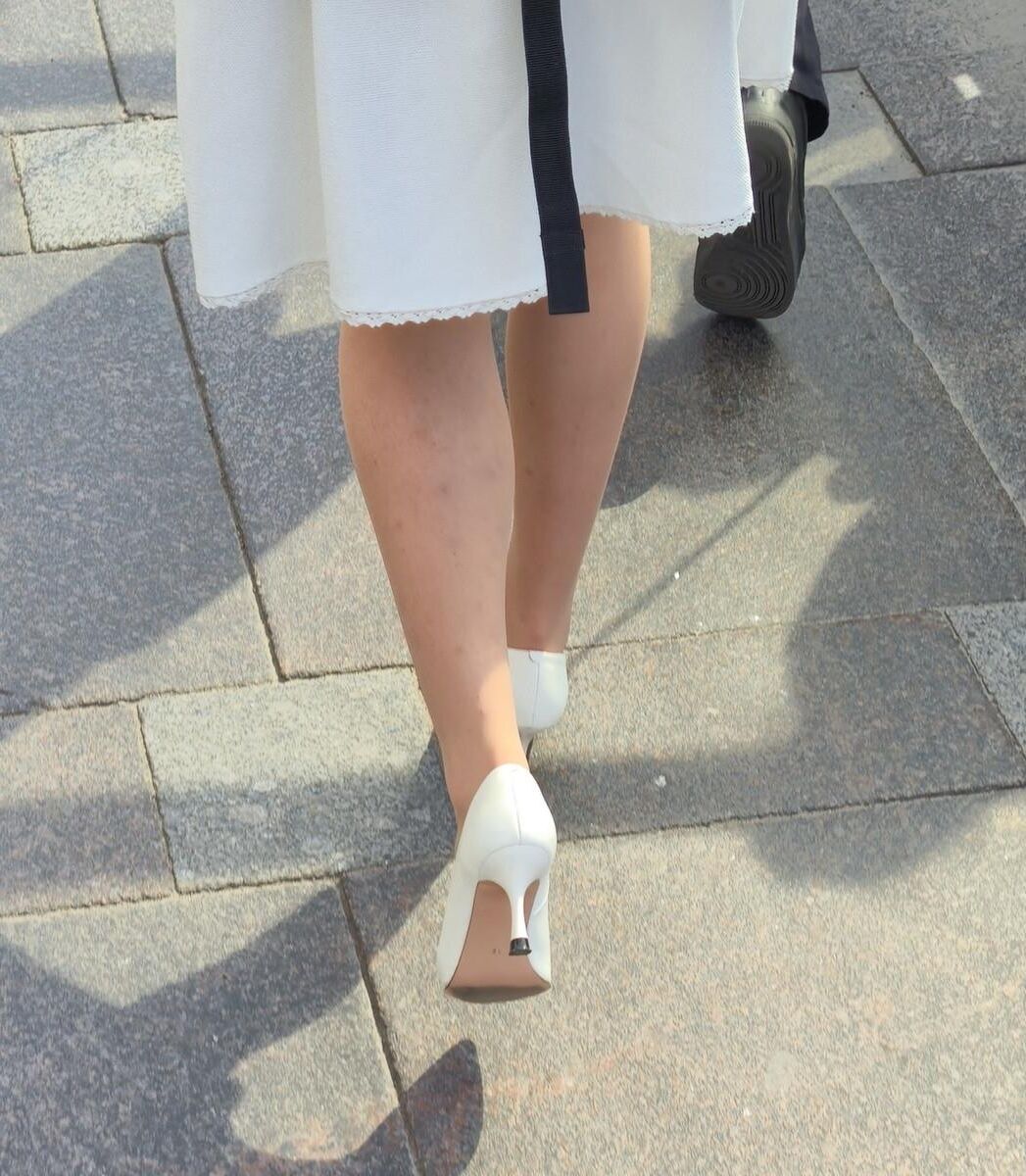 Menina de calças calças nus, saltos brancos e vestido branco