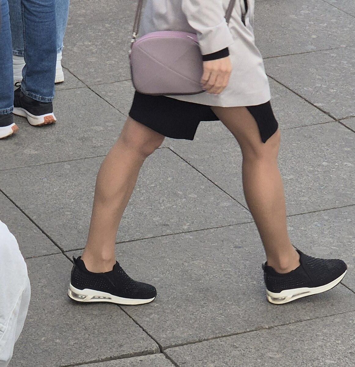 Garota em meia -calça bronzeada e mini -saia