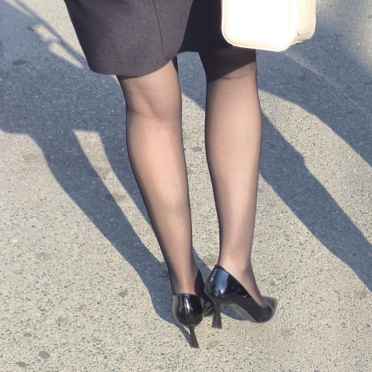 黒いタイツの女性、特許革のかかと、ミディスカート