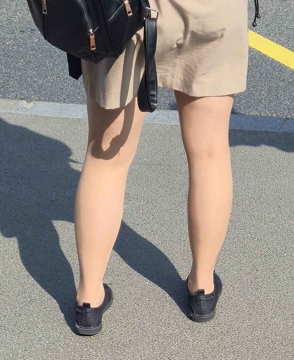 日焼けした光沢のあるパンストとミニスカートの女の子