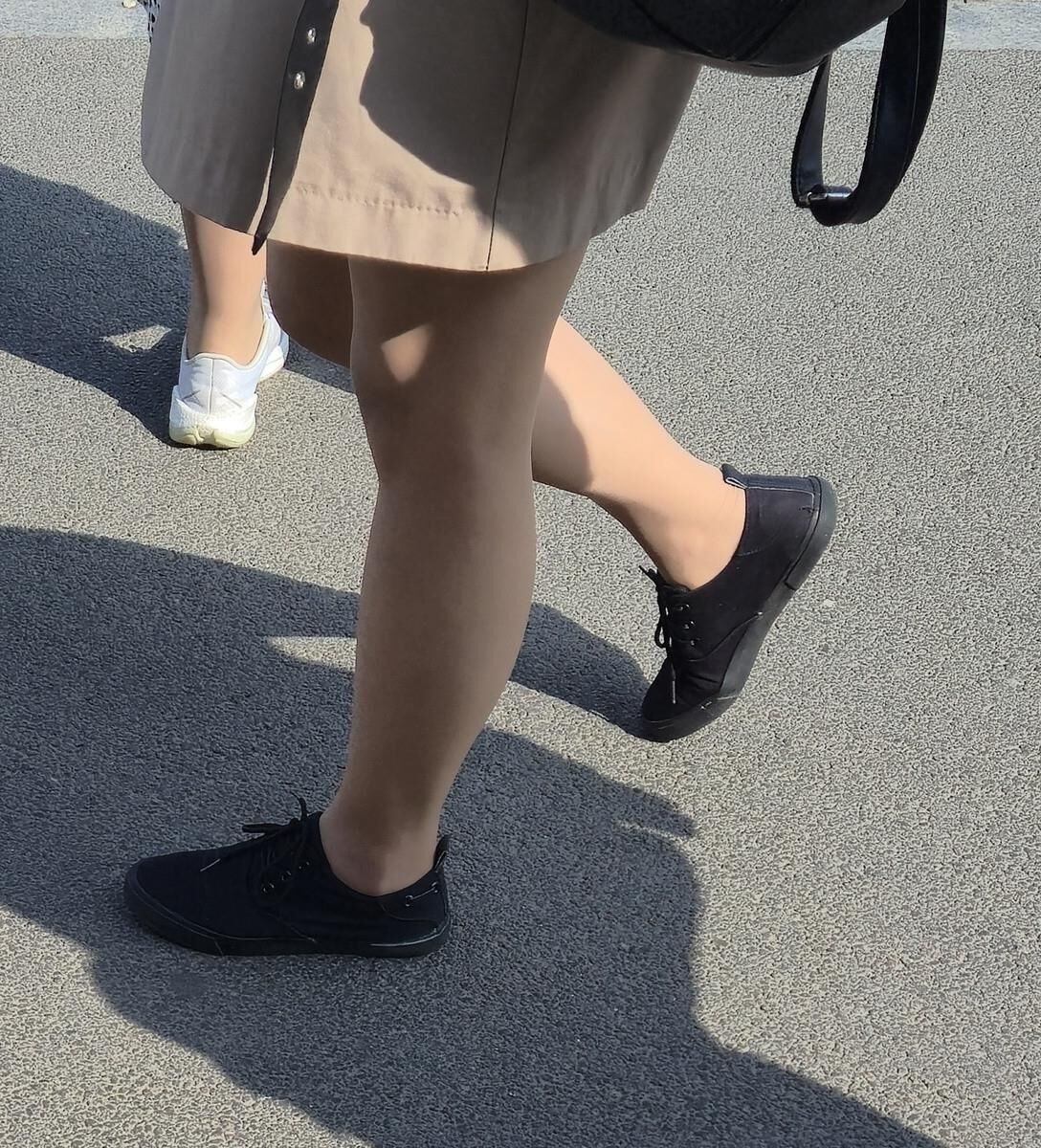 日焼けした光沢のあるパンストとミニスカートの女の子