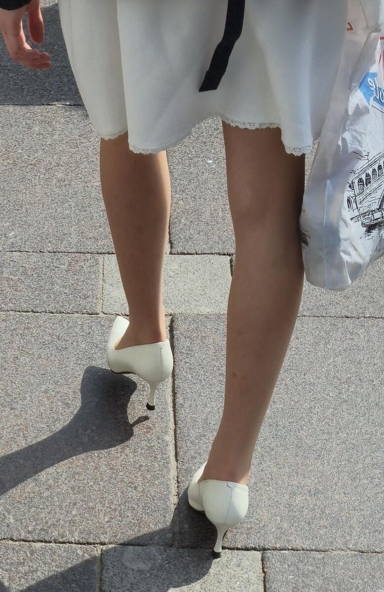 Menina de calças calças nus, saltos brancos e vestido branco