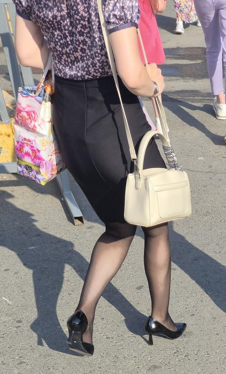 黒いタイツの女性、特許革のかかと、ミディスカート