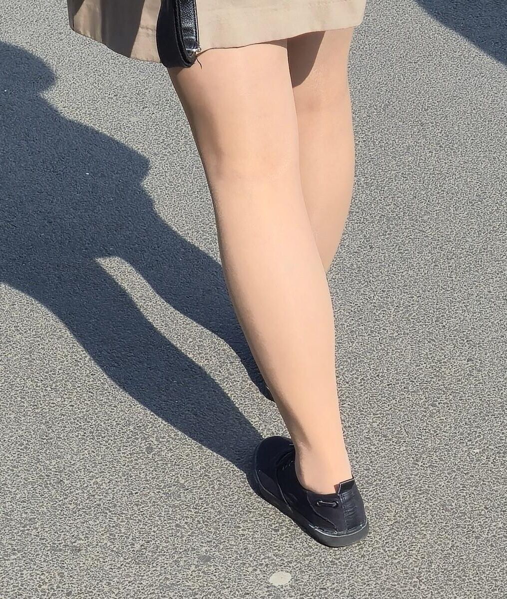 日焼けした光沢のあるパンストとミニスカートの女の子