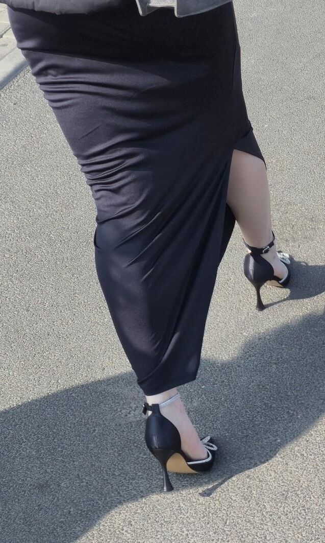 セクシーなサテンのかかとと長いスカートの女性