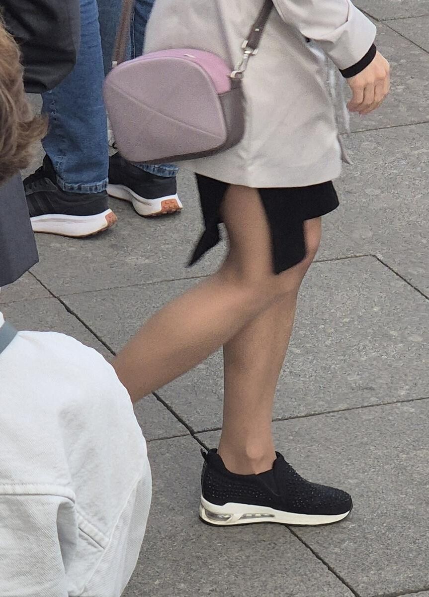 Garota em meia -calça bronzeada e mini -saia