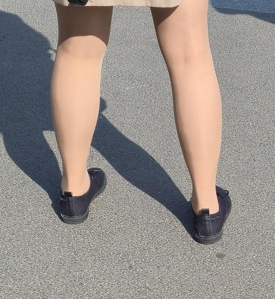 日焼けした光沢のあるパンストとミニスカートの女の子