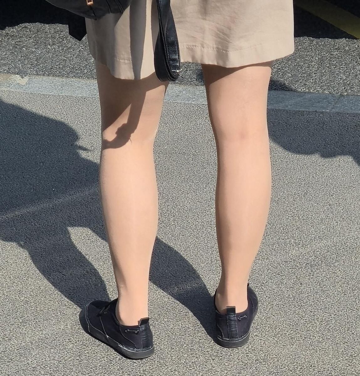 日焼けした光沢のあるパンストとミニスカートの女の子