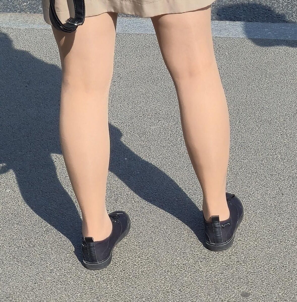 日焼けした光沢のあるパンストとミニスカートの女の子