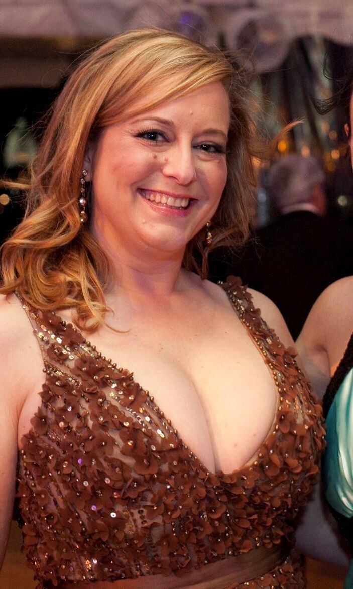 彼女の大きなおっぱいの裂け目を提示する巨乳の熟女の女