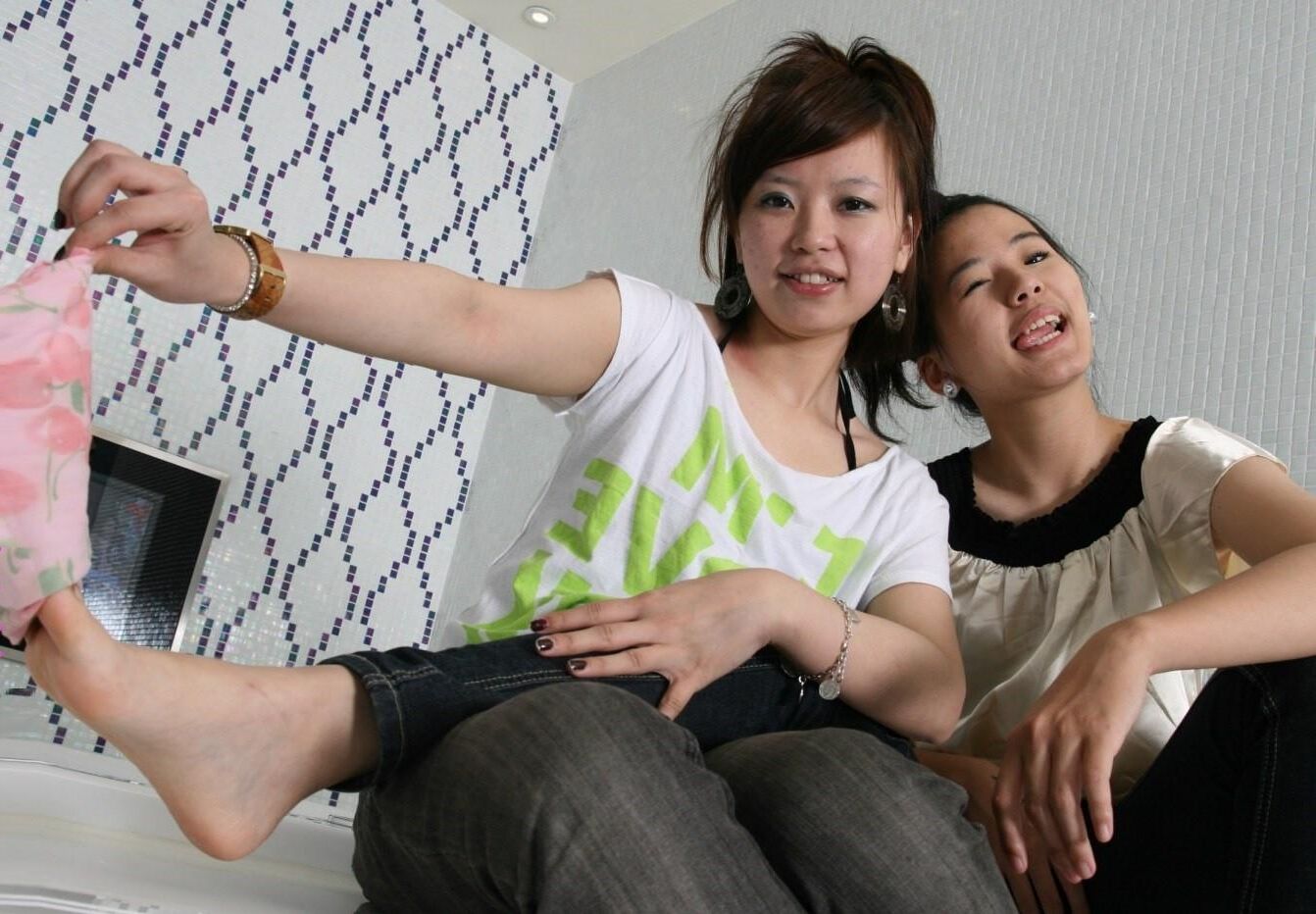 2人の中国人の少女が足でからかいます