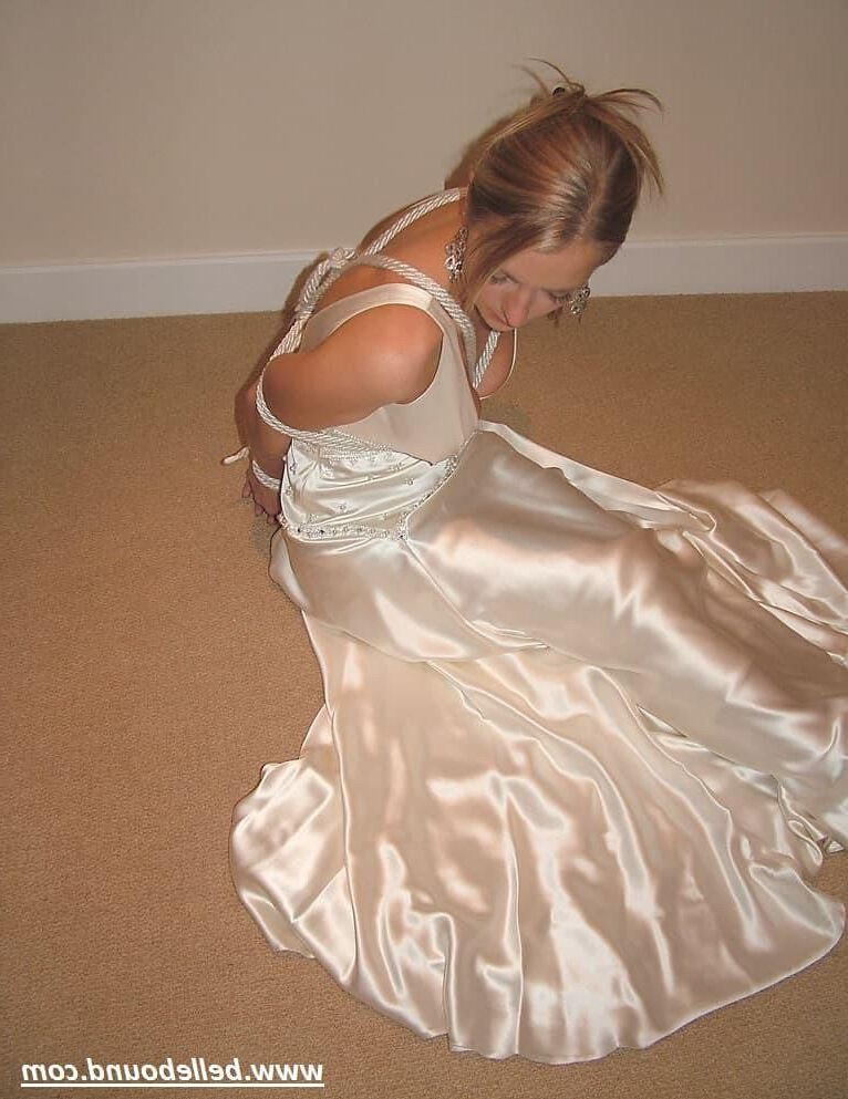 Charlie Dee atado con vestido de satén blanco