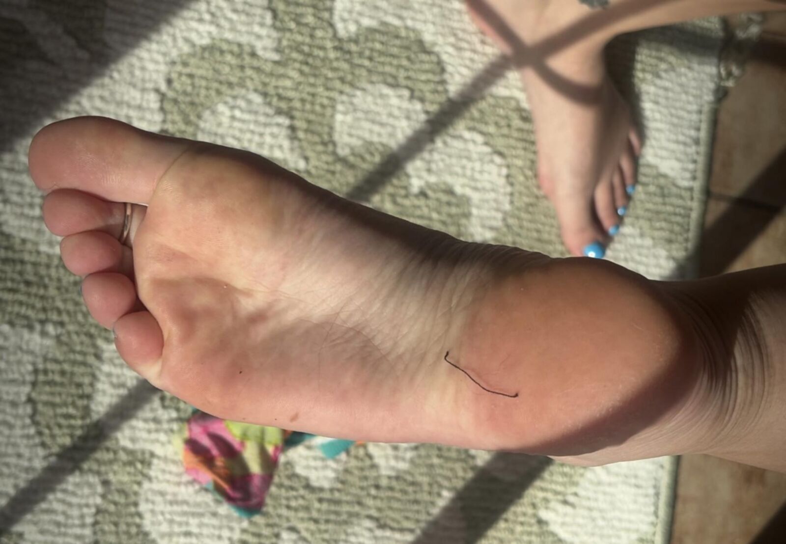 Ash removing socks to show her blue toes and hot soles