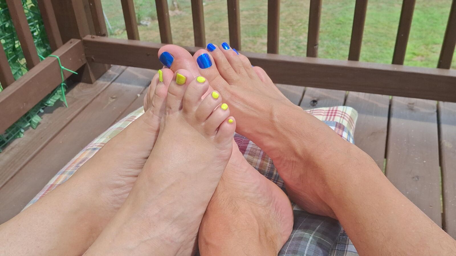 Two pairs of feet playing footsie in the sun