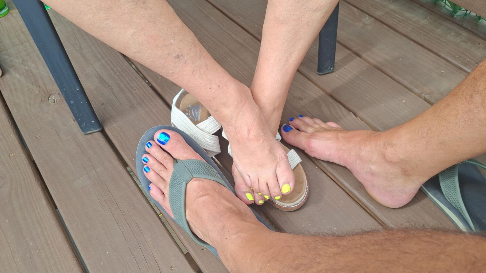 Two pairs of feet playing footsie in the sun