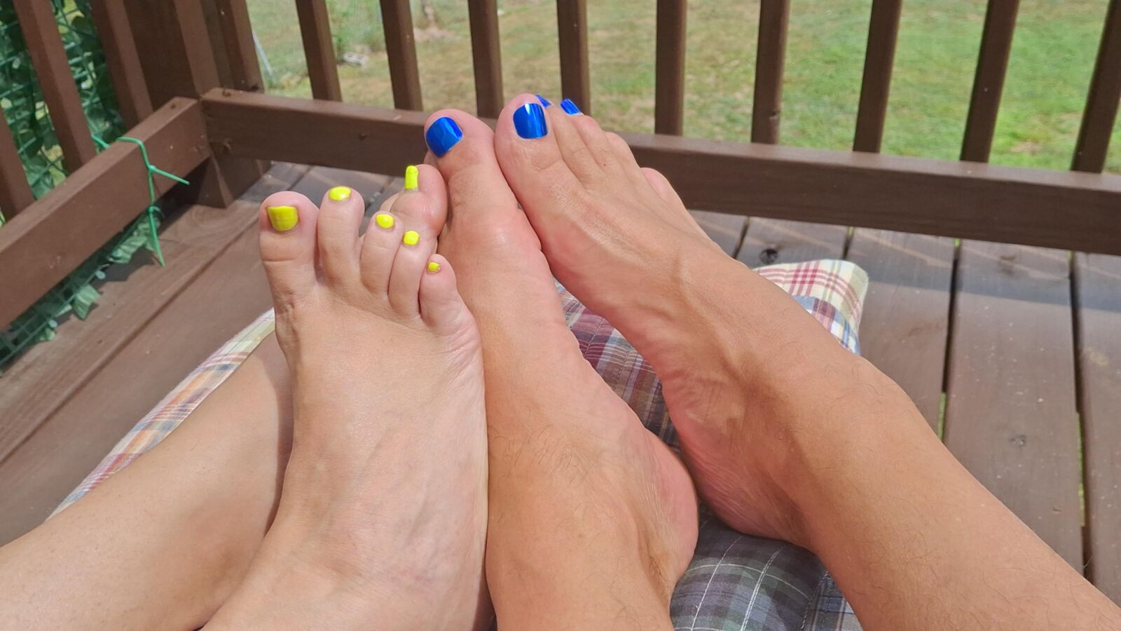 Two pairs of feet playing footsie in the sun