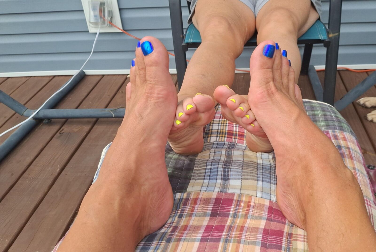 Two pairs of feet playing footsie in the sun