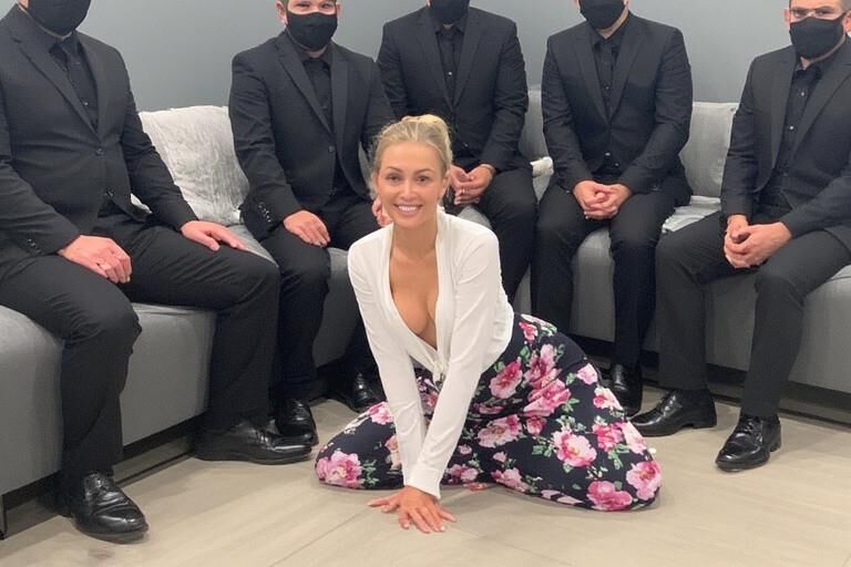 Femme chaude entourée d'hommes masqués