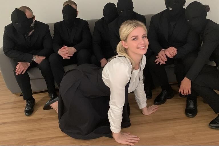 Femme chaude entourée d'hommes masqués