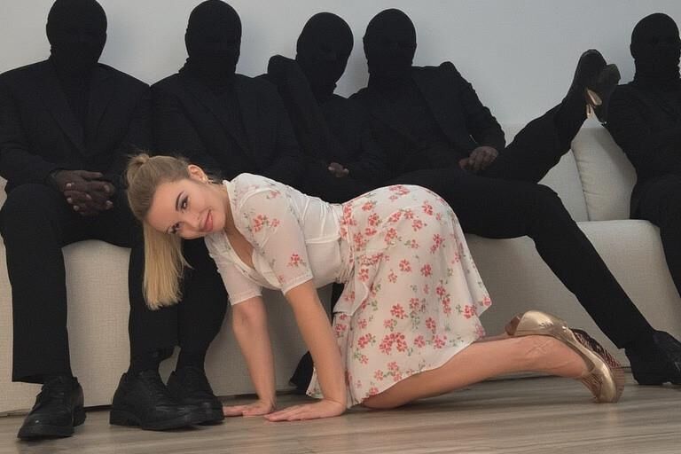 Femme chaude entourée d'hommes masqués